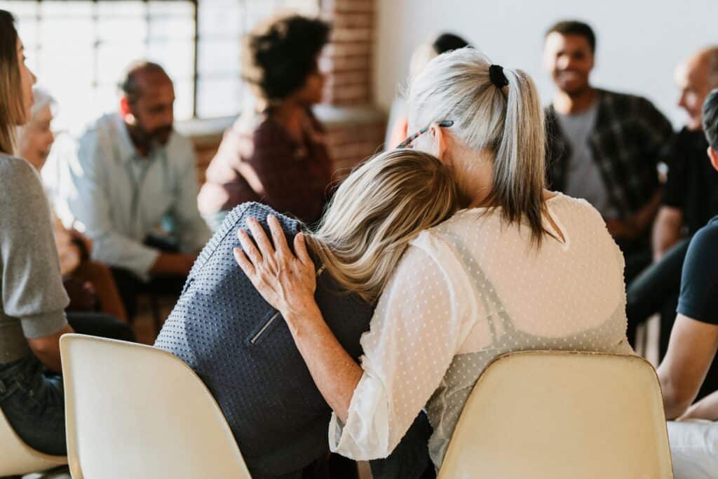 A woman recieves comfrot during group therapy boca raton