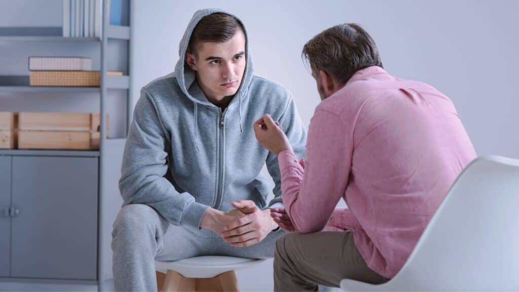 A young man listens to his therapist during borderline disorder treatment in Boca Raton.