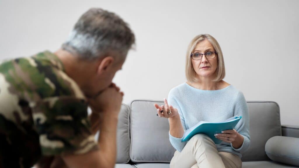 A professional offering counseling to a veteran during PTSD treatment in Boca Raton.